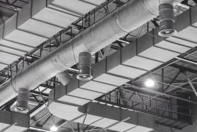 HVAC Duct Cleaning, Ventilation pipes in silver insulation material hanging from the ceiling inside new building.